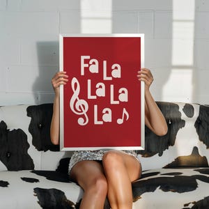 May include: A red poster with a white treble clef and the words "Fa La La La La" printed on it.