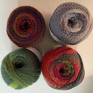 May include: Four skeins of yarn in different color combinations. The yarn is a mix of green, red, orange, blue, and grey.