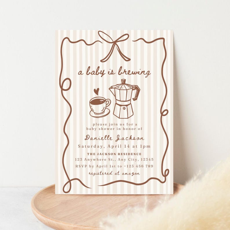 May include: Baby shower invitation with a vertical striped background. The text "a baby is brewing" is above an illustration of a coffee cup and a moka pot. The invitation includes details for Danielle Jackson's baby shower.
