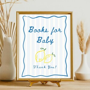 K&ouml;nnte beinhalten: Gerahmtes Schild mit dem Text "Books for Baby" in blauer Schrift, mit zwei gelben Zitronen-Illustrationen. Das Schild hat einen blauen, wellenf&ouml;rmigen Rand und einen gestreiften Hintergrund. Die Worte "Thank You!" stehen unten.