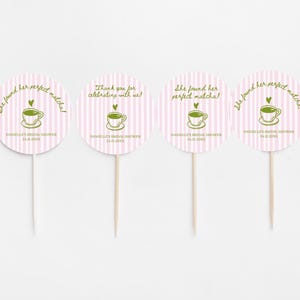 May include: Four round cupcake toppers with pink and white striped backgrounds. Each topper has a green teacup graphic and text that reads "She found her perfect matcha!" or "Thank you for celebrating with us!" and "Danielle's Bridal Shower 24.11.20XX".