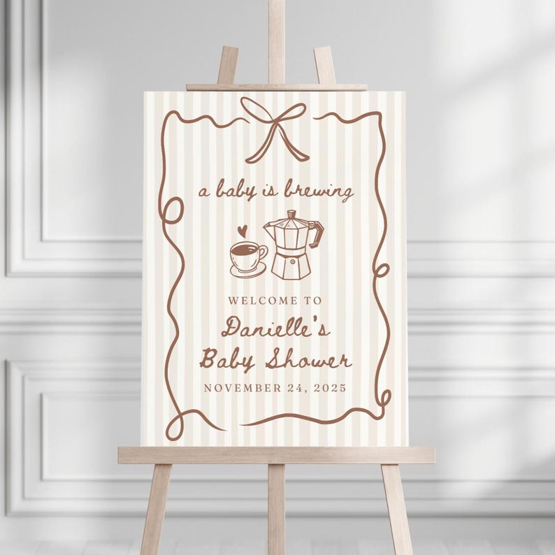 May include: A beige and brown baby shower sign with a coffee pot and cup illustration. The text reads "a baby is brewing" and "Welcome to Danielle's Baby Shower November 24, 2025".