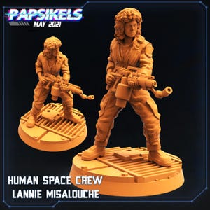 Op de afbeelding: Oranje harsfiguur van een Human Space Crew-lid, Lannie Misalouche, met een futuristisch wapen. De figuur staat op een cirkelvormig platform met een rasterpatroon. De tekst "Papsikels May 2021" en "Human Space Crew Lannie Misalouche" zijn zichtbaar.