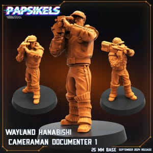 May include: Three orange-coloured miniature figurines of a cameraman in a uniform, holding a camera. The figurines are on black bases. Text on the image reads "WAYLAND HANABISHI CAMERAMAN DOCUMENTER 1" and "25 MM BASE SEPTEMBER 2024 RELEASE".