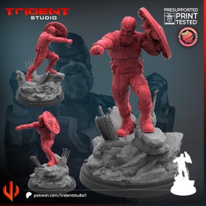 Op de afbeelding: Rode 3D-geprinte beeldjes van een superheld in actieposes, met een schild. De figuren staan op een rotsachtige basis. Het Trident Studio-logo en de tekst "Presupported Print Tested" zijn zichtbaar.