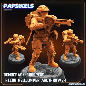 Puede incluir: Figuras en miniatura de color naranja de soldados futuristas, cada uno armado con un rifle y con una armadura detallada. Las figuras están sobre bases circulares grises. El texto "DEMOCRACY TROOPERS RECON HELLJUMPER ARCTHROWER" se muestra en la parte inferior.