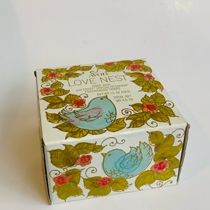 Puede incluir: Una caja blanca con un dise&ntilde;o floral con p&aacute;jaros azules y flores rojas. La caja contiene un jabonera y tres jabones perfumados "Special Occasion". La caja est&aacute; etiquetada "Avon Love Nest" y tiene un peso neto de 4,5 onzas.