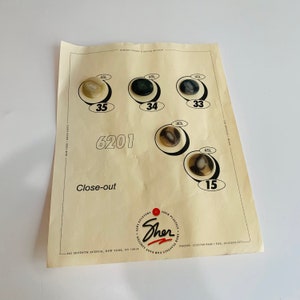 May include: A close-out sale advertisement for buttons from Sher Plastics. The advertisement features a variety of buttons in different sizes and colors, including black, white, and brown. The text on the advertisement includes the company name, address, phone number, and the phrase "Close-out."