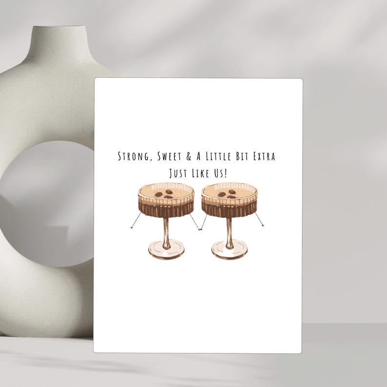 May include: A white card with the text "Strong, Sweet & A Little Bit Extra Just Like Us!" and a drawing of two brown cocktails with coffee beans on top.