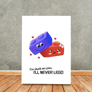 May include: A white card with a blue and red Lego block design. The blocks have faces and the text "I'm stuck on you, I'LL NEVER LEGO".