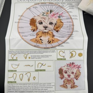May include: A close-up of a printed embroidery pattern of a dog with a flower crown. The pattern includes instructions for different embroidery stitches, including French knot, stem stitch, straight stitch, satin stitch, and lazy daisy. The text on the page reads "Description of embroidery stitch" and "No. 819".