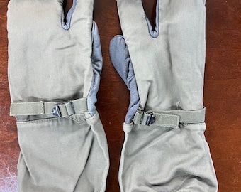 May include: A pair of olive green fingerless gloves with black straps and adjustable buckles. The gloves have a fleece lining and are made of a water-resistant material.