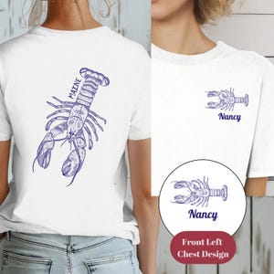 May include: White t-shirt with a blue lobster illustration on the back and the word "MAINE" written vertically. The front of the shirt has a smaller blue lobster illustration and the name "Nancy" written below it.