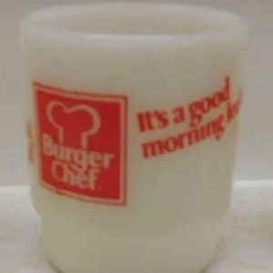 May include: White ceramic mug with a red logo for Burger Chef. The logo features a chef's hat and the text "Burger Chef". The mug also has the text "It's a good morning to..." in red.