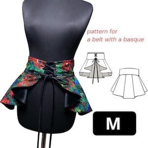 Puede incluir: Un cinturón con estampado floral con una basque, exhibido en un maniquí negro. El cinturón presenta flores rojas, verdes y azules sobre un fondo negro, con una parte delantera con cordones y un lazo. La imagen también incluye un diagrama de patrón y la letra "M".