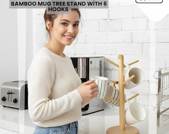 May include: A bamboo mug tree stand with six hooks, holding several mugs. The stand is light brown and has a round base. The text "BAMBOO MUG TREE STAND WITH 6 HOOKS" is at the top of the image.