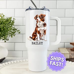 May include: White insulated tumbler with a handle, featuring a detailed illustration of a brown and white dog. The dog's name, "BAILEY," is printed below. A black and silver straw is inserted in the lid.