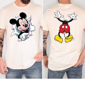 The image is a collage of two photos of a man wearing a white t-shirt with a Mickey Mouse design on the front and a back view of the same design.