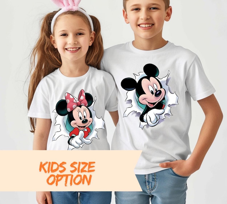 A young girl and boy are standing next to each other, both wearing white t-shirts with cartoon characters on them.