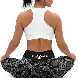 Könnte beinhalten: Schwarz-weiße Leggings mit Schlangenmuster, hoher Taille und einem weißen Logo mit der Aufschrift "THE@NILE" auf der Rückseite.