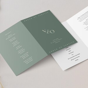 May include: An open wedding program with a sage green cover featuring the initials "V&O" in a delicate script. The text "ORDER OF SERVICE" is printed at the top and bottom. The date and location are also printed on the cover.