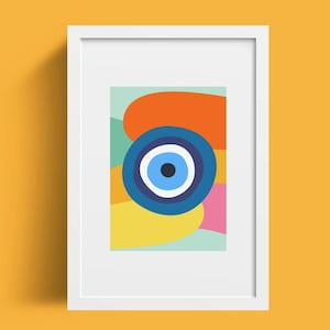 May include: A framed print with an abstract design featuring a blue evil eye surrounded by colourful shapes in shades of orange, yellow, pink, and green.