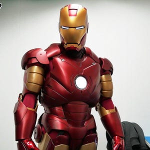 Könnte beinhalten: Ein rotes und goldenes Iron Man Kostüm mit einem weißen Licht in der Brust. Das Kostüm ist aus Kunststoff und hat eine metallische Oberfläche.