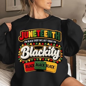 Puede incluir: Sudadera negra con la palabra "Juneteenth" en rojo, verde y amarillo, con la frase "I'm black every day, but today I'm Blackity." Debajo, tres parches rectangulares que dicen "Black" en rojo, verde y amarillo.
