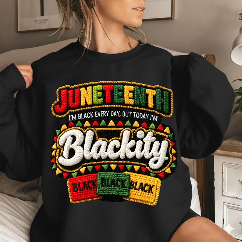 Puede incluir: Sudadera negra con la palabra "Juneteenth" en rojo, verde y amarillo, con la frase "I'm black every day, but today I'm Blackity." Debajo, tres parches rectangulares que dicen "Black" en rojo, verde y amarillo.