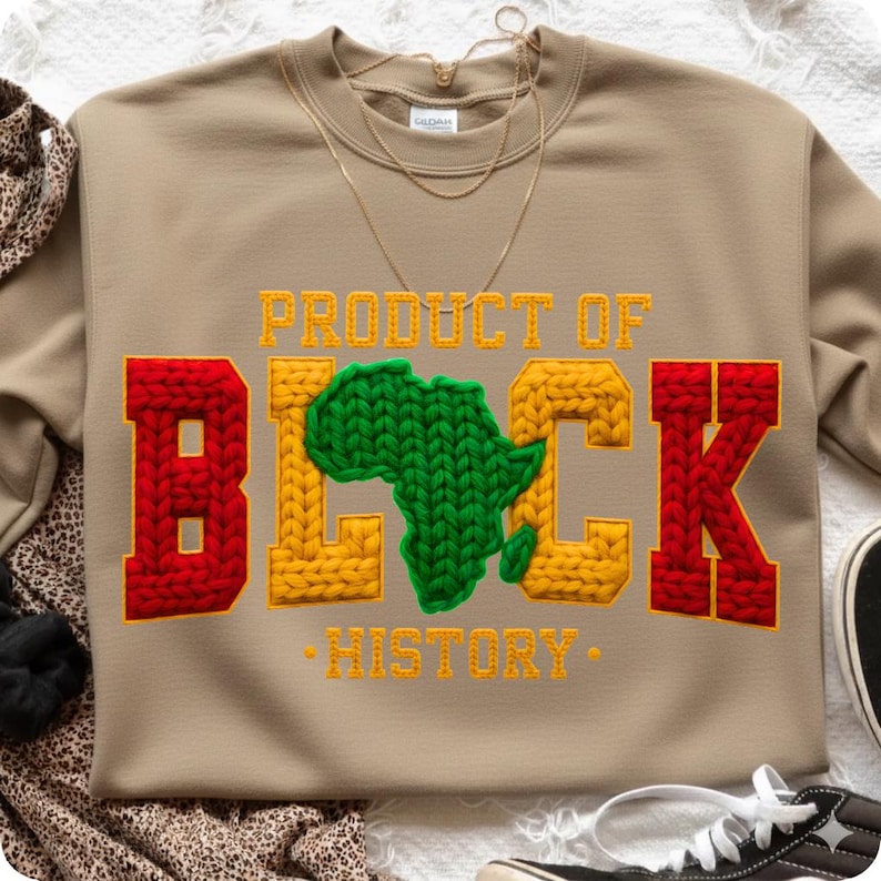 May include: Tan sweatshirt with the words "PRODUCT OF BLACK HISTORY" in yellow and red knit lettering. The letter "B" is red, the "LACK" is yellow, and the "K" is red. A green knit Africa map is in the center.