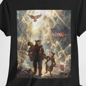 Op de afbeelding: Zwart T-shirt met een gedetailleerde illustratie van twee antropomorfe wasberen die naar het licht lopen, met een Amerikaanse vlag en een adelaar op de achtergrond. De wasberen dragen kleding en dragen uitrusting.