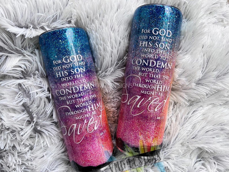 May include: Two colorful, glittery tumblers with a Christian quote about God sending his son into the world to save it. The quote is "For God did not send his son into the world to condemn the world, but that the world through him might be saved." The tumblers have a gradient of blue, pink, and orange.
