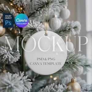May include: A white, round Christmas ornament mockup hanging on a snow-covered tree. The ornament has a gold string and the text "MOCKUP" in large letters. Below, it reads "PSD & PNG CANVA TEMPLATE".