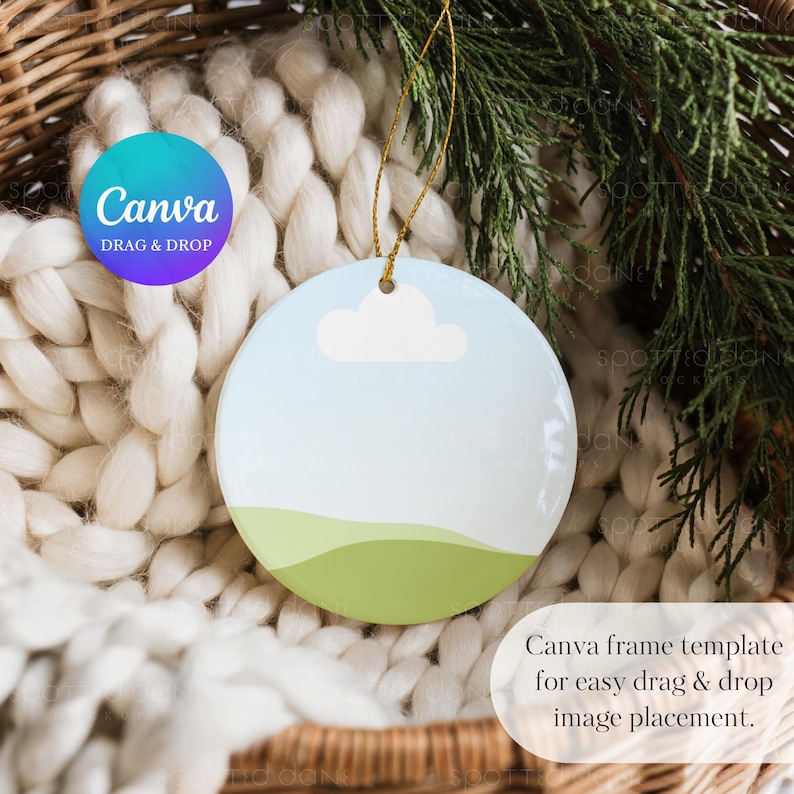 May include: A round ceramic ornament with a landscape design featuring a blue sky, a white cloud, and green hills. The ornament has a gold string for hanging. The text "Canva Drag & Drop" is visible.