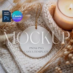 May include: A white, round ceramic ornament with the word "MOCKUP" printed on it. The ornament has a gold string for hanging and the text "PSD & PNG CANVA TEMPLATE" below the word "MOCKUP". The ornament is on a white knitted surface.