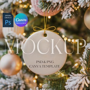 May include: A round, off-white Christmas ornament mockup with a gold string, hanging against a blurred background of a decorated Christmas tree. The ornament has the word "MOCKUP" and the text "PSD & PNG CANVA TEMPLATE".