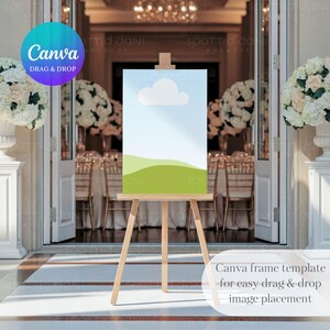 May include: A wooden easel with a blank canvas sign, perfect for displaying wedding information or a welcome message. The easel is set up in front of a pair of white double doors with a floral arrangement on each side.