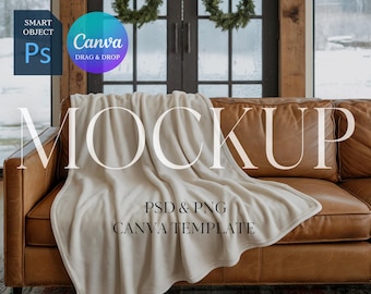 May include: A cream-colored blanket draped over a brown leather sofa. The word "MOCKUP" is displayed in large, elegant letters. The image also includes text indicating it is a PSD and PNG Canva template.
