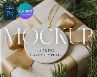 Puede incluir: Maqueta de adorno blanco y redondo con una cuerda dorada, colocada sobre un regalo envuelto con una cinta dorada. El regalo está envuelto en papel blanco con un diseño de copo de nieve. La palabra "MOCKUP" se muestra.