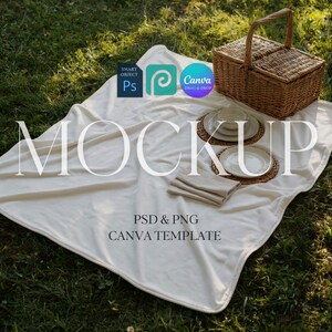 Puede incluir: Una escena de picnic con una manta blanca sobre hierba verde. Una cesta de mimbre, platos, cuencos y servilletas están colocados sobre la manta. La palabra "MOCKUP" se muestra, junto con "PSD & PNG CANVA TEMPLATE".