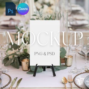 May include: A white card with the text "MOCKUP" and "PNG & PSD" on a black easel stand. The card is on a white tablecloth with gold cutlery, a glass of water, and a bouquet of white flowers.