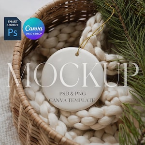 May include: A white ceramic ornament with a gold string, resting in a woven basket filled with a cream-colored knitted blanket. The word "MOCKUP" is displayed across the ornament. The image also includes text that says "PSD & PNG CANVA TEMPLATE".