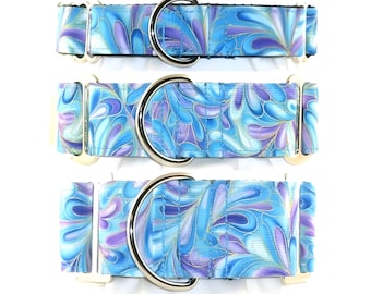 May include: Three dog collars with a blue, purple, and gold abstract pattern. Each collar has a silver metal D-ring and metal hardware. The collars are displayed on a white background.