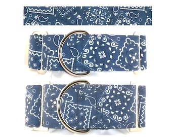 May include: Two blue dog collars with a white paisley pattern. Each collar has a silver metal D-ring and a silver metal buckle. The collars are displayed on a white background.