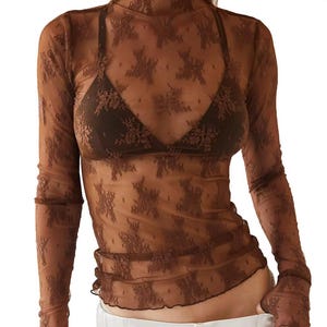 Könnte beinhalten: Ein braunes, durchsichtiges Langarm-Oberteil mit Blumenmuster. Das Oberteil hat einen hohen Kragen und eine figurbetonte Silhouette.