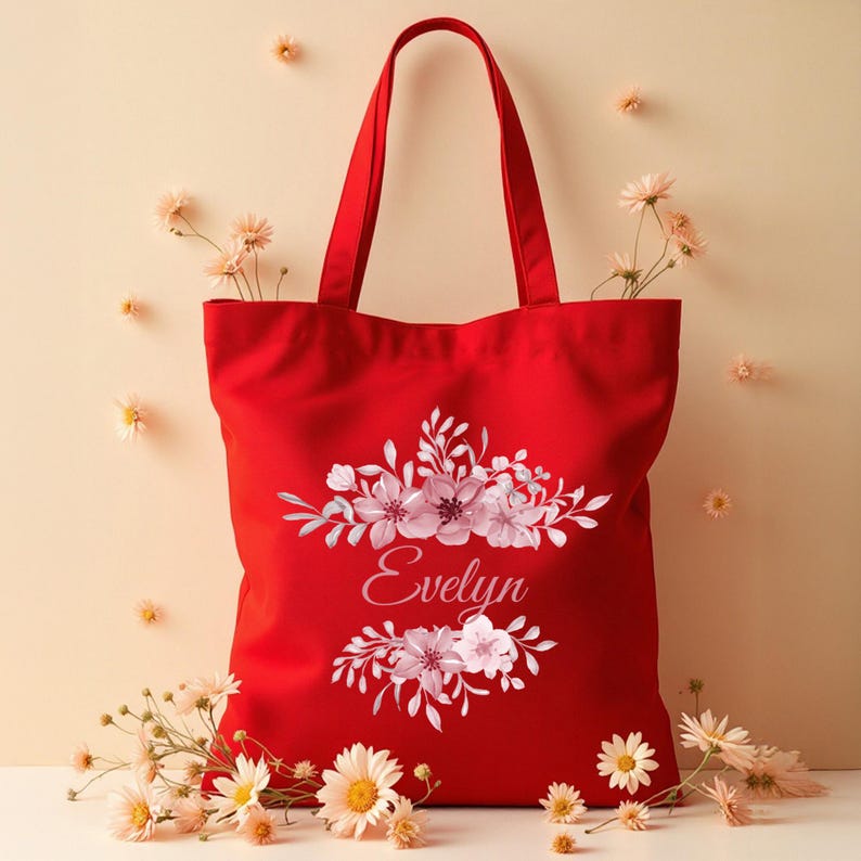 May include: Red canvas tote bag with a floral design and the name "Evelyn" printed in pink.
