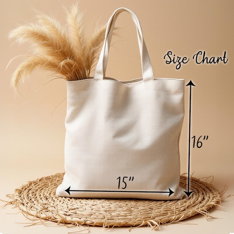 May include: A white canvas tote bag with a 15 inch width and 16 inch height. The bag is sitting on a woven straw mat.