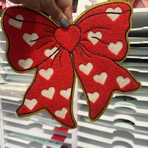 Strykmärke med röd chenille-hjärtrosett, glitterkontur