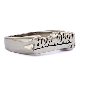 May include: A silver ring with the word "Berkeley" engraved in a stylized font.