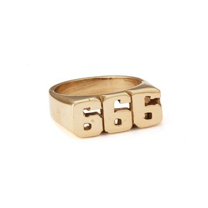 Puede incluir: Un anillo de color dorado con el número "666" grabado en él.